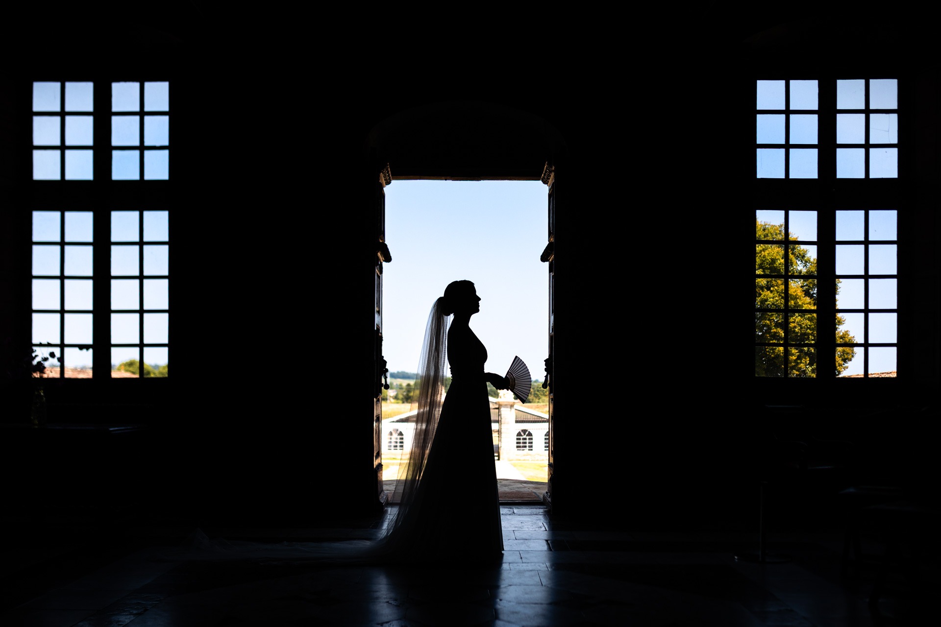 Portrait de la la mariée dans l'encadrure de la porte du château de Malle - Photographe mariage Charente