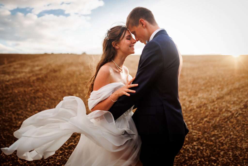 Photo de couple au coucher de soleil avec le vent dans la robe - Photographe mariage Charente Antoine OLLIER